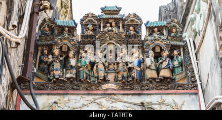 Composition of figurines showing a crowded city scene on the roof of Thien Hau Temple (erected in c. 1760). Cho Lon, Ho Chi Minh City, Vietnam. Stock Photo