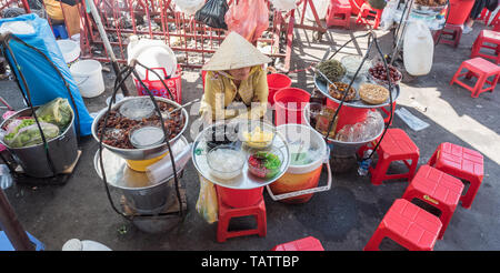 Ho Chi Minh City, Vietnam: a vendor sits by plates with ingredients for sam bo luong, a cold sweet soup (dish of Chinese origin) Cho Binh Tay market.