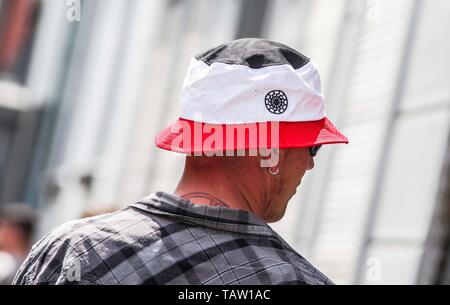 Dortmund, Nordrhein Westfalen, Germany. 25th May, 2019. A neonazi in  Dortmund, Germany wears a hat with the colors of Germany\'s 1933-35 flag  with a Black Sun nazi esoteric embroidery. Prior to the