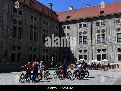 Munich, Germany. 24th May, 2019. People ride bicycles on a square ouside the Munich Residenz in Munich, Germany, May 24, 2019. Located in the northern foothills of the Alps in southern Germany, Munich is the capital of the state of Bavaria. It is one of Germany's major economic, cultural, scientific, technological and transportation centers and one of Europe's most prosperous cities. Credit: Lu Yang/Xinhua/Alamy Live News Stock Photo