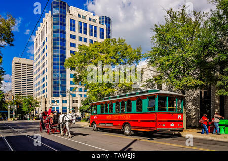 A horse-drawn carriage passes a trolley bus, Sept. 12, 2015, in downtown Memphis, Tennessee. Stock Photo