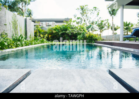PHU QUOC, VIETNAM JUNE 28, 2017: Swimming pool with stair and wooden deck at hotel. Stock Photo