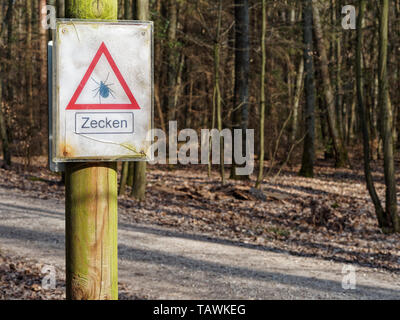 FORCHHEIM (BAVARIA), GERMANY - APRIL 2 2019 - prominent sign in a forest, warning visitors of the danger of ticks. Stock Photo