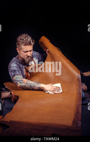 Artisan of leather demostrating leather cutting process . Stock Photo