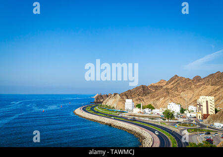 Beautiful landscape of Oman with a curvy seaside road, mountains, blue sky and blue sea. From Muttrah, Muscat. Stock Photo