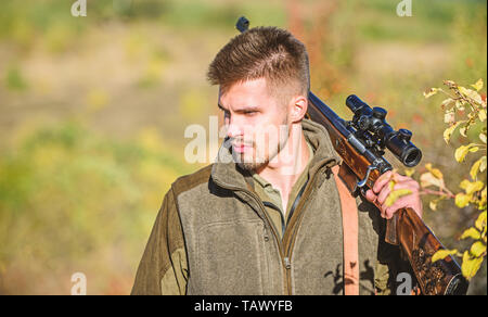 Man hunter with rifle gun. Boot camp. Hunting skills and weapon equipment. How turn hunting into hobby. Military uniform fashion. Bearded man hunter. Army forces. Camouflage. observing walk. Stock Photo