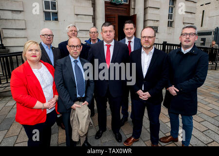 (left to right) Victim Adrian Rogan's daughter Emma Rogan, Gerry Carson of the NUJ Belfast Branch, investigative journalist Barry McCaffrey, David Davis MP, Gerry Kelly MLA, solicitor Niall Murphy, Belfast Lord Mayor John Finucane, investigative journalist Trevor Birney and Irish Senator Niall O Donnghaile stand outside Belfast High Court ahead of a case regarding Mr Birney and Mr McCaffrey's arrest over the use of material allegedly stolen from the Police Ombudsman for Northern Ireland (PONI). Picture date: Tuesday May 28, 201 Stock Photo