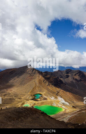 New Zealand popular tourist hiking hike in Tongariro Alpine Crossing National Park. Tramping trampers couple hikers walking on famous destination in N Stock Photo