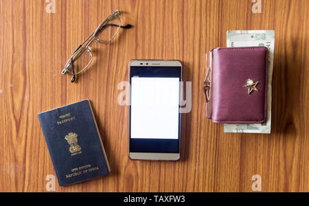Business still life concept. Personal accessories on table desk. Indian passport, money purse, paper currency, eye glasses and mobile phone with blank Stock Photo