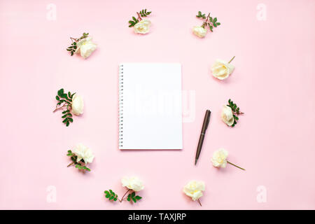 Feminine home office workspace. Notebook with copy space. Flat lay, magazines, social media, top view. Beauty business blog concept. White flowers on  Stock Photo
