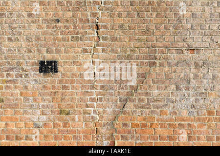 Large cracks in a brick wall due to subsidence Stock Photo