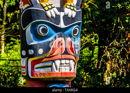 Details of a section of the the colorful 'Thunderbird House Post Totem Pole' depicting the face of a Grizzly Bear. The pole is located in Stanley Park Stock Photo