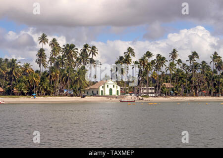 In front of the sea and half the coconut grove, Chapel of St. Benedict on Carneiros beach, Pernambuco, Brazil. Stock Photo