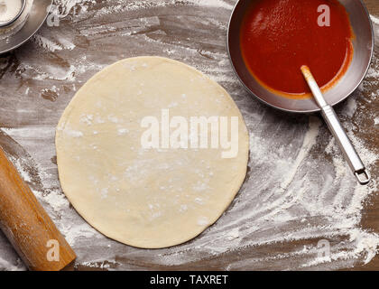 Raw Pizza Base And Ketchup. Rolled Out Dough Stock Photo