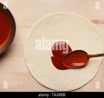 Adding Ketchup. Chef Cooking Italian Pizza, Spreading Tomato Sauce Stock Photo