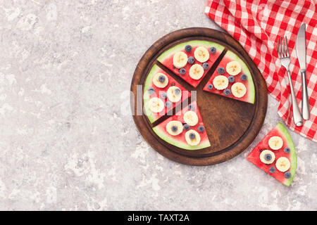 Sliced juicy watermelon pizza with blueberries and bananas Stock Photo