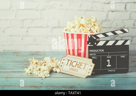 Cinema movie concept, popcorn and clapperboard on a wooden table Stock Photo