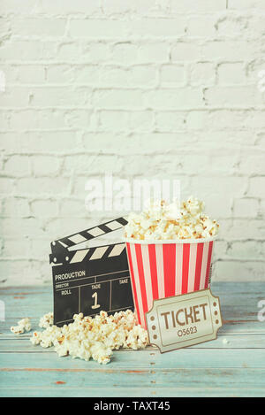 Cinema movie concept, popcorn and clapperboard on a wooden table Stock Photo