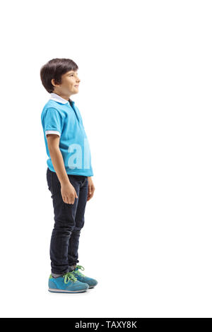 Full length profile shot of a smiling boy standing and waiting isolated on white background Stock Photo