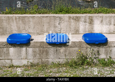 Blue plastic seats mounted on concrete Stock Photo