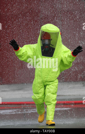 fireman wears a special phosphorescent protective suit to extinguish a fire caused by chemical substances Stock Photo