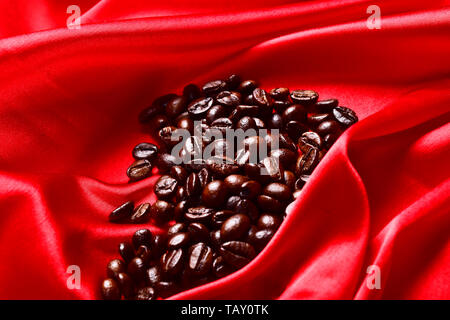 Abstract silk luxury background, piece of cloth, deep red cloth texture with aroma coffee beans on it Stock Photo