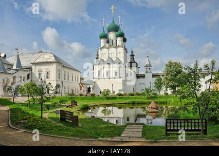 = At the Small Pond in Rostov Kremlin =  View from a small park on the grounds of Rostov Kremlin on the well-maintained pond with a wooden house for b Stock Photo