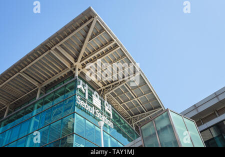 Seoul, South Korea - March 2018: exterior glass facade of the Station, a name also reported in the Korean alphabet, taken from below. Stock Photo