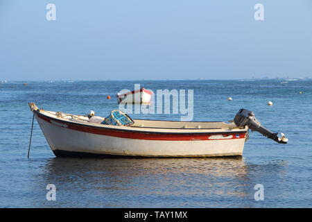 Small motorboat at anchor in Brittany during summer Stock Photo