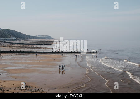 Cromer, UK - April 20, 2019: People enjoying sunny day on a beach in Cromer, a seaside town in Norfolk and a popular family holiday destination in UK. Stock Photo