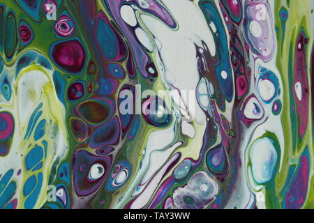 Close-up on a section of an abstract acrylic pour painting that is done in teal, green, purple, magenta, and white. Stock Photo
