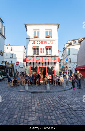 Paris, France - April 12, 2019 : People sitting at the terrace of Le consulat restaurant in Montmartre in the evening on a sunny day Stock Photo