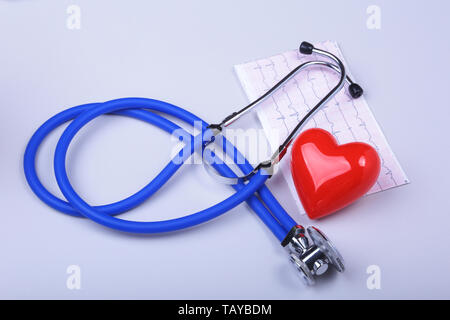 Stethoscope, RX prescription, red heart and assorted pills on white table with space for text. Stock Photo