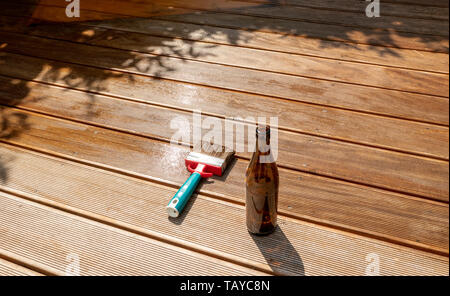empty beer bottle and a brush are lying on the half recessed terrace with glaze Stock Photo