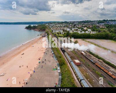 Aerial View of a Steam Passenger Train Puffing Smoke by Devon coastline on a summer Day Stock Photo