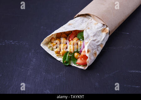 Vegan wraps in pita with chickpeas and mashed avocado on dark background Stock Photo