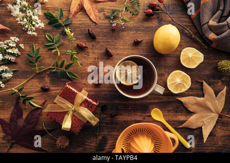 Flat lay rose hip herbal tea in a cup with slice of lemon and autumnal season decoration Stock Photo