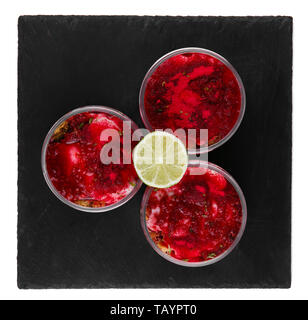Raspberry cheesecake dessert in a jar on a black stone plate isolated on a white background