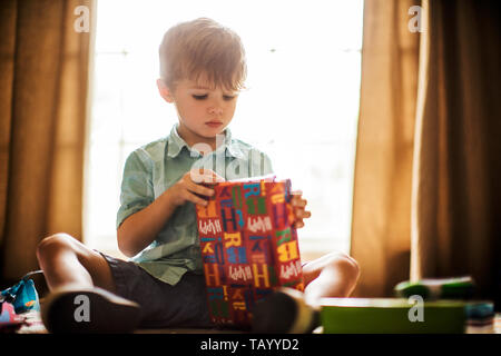 Young boy opening birthday presents. Stock Photo