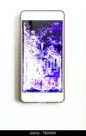 phone with a broken screen on white table. dark spots of purple, blue and black over the entire surface screen, service concept,  top view Stock Photo