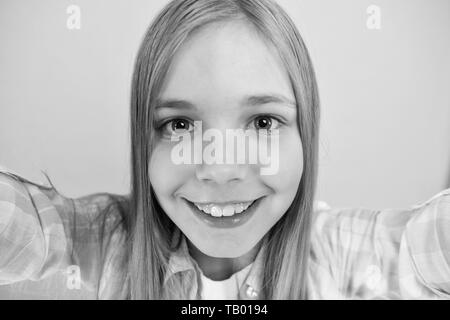 Let me take selfie. Child girl hold smartphone takes photo. Child kid happy face. Video call concept. Video conference camera. Girl long hair hold smartphone taking selfie. Selfie for social networks. Stock Photo