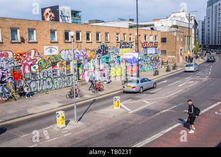 Shoreditch, London, England, UK - April 2019: Hipster man crossing the road on Bethnal Green Road near Shoreditch high street station and BOXPARK Stock Photo