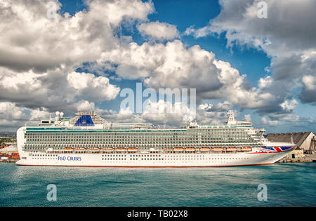 Bridgetown, Barbados - December 12, 2015: P O Cruises. Azura cruise ship docked in sea port on cloudy sky. Transportation. Travelling by sea. Recreation and summer vacation. Stock Photo