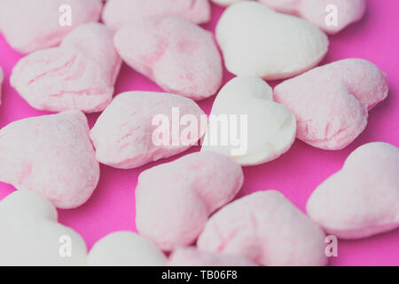 background picture with heart-shaped hard candies on a pink background Stock Photo