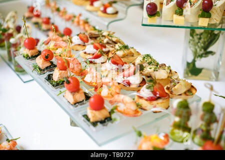 Catering. Off-site food. Buffet table with various canapes, sandwiches, hamburgers and snacks. Stock Photo