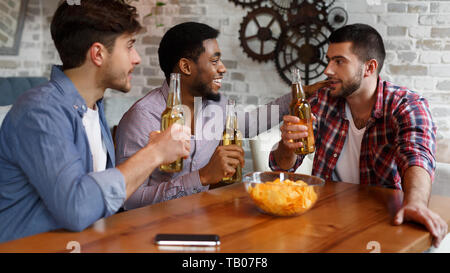 Mates Eating Chips And Drinking Beer In Pub Stock Photo