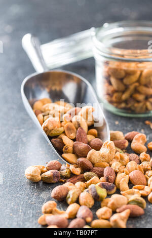Spicy flavoured nuts. Mix of nuts in scoop. Stock Photo