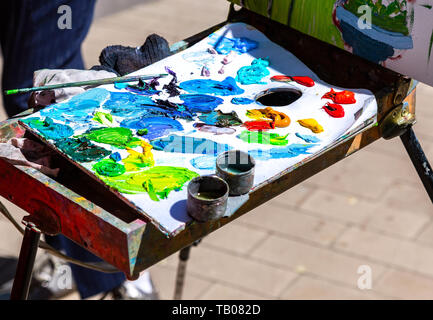 Artist's palette with oil paints and brush, close-up. Stock Photo