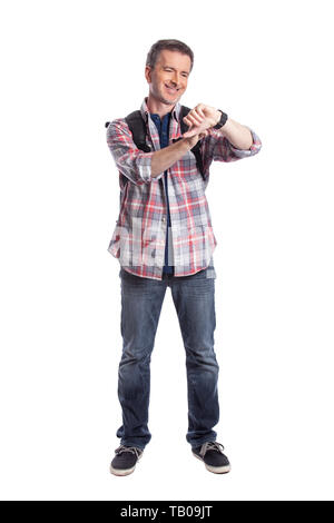 Middle-aged man or senior citizen checking heart rate pulse with health apps on a smartwatch.  He also looks like a hiker checking the wearable techno Stock Photo