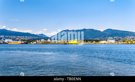 View of the North Shore of the Vancouver Harbor with Grouse Mountain in the background. Viewed from the Stanley Park Seawall pathway in BC, Canada Stock Photo